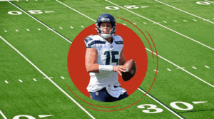 A football player in a Seattle Seahawks uniform holds a football, preparing to throw. He is centered in a red circle overlay, set against the green field—embodying the drive and teamwork found at every Unishippers Franchise.